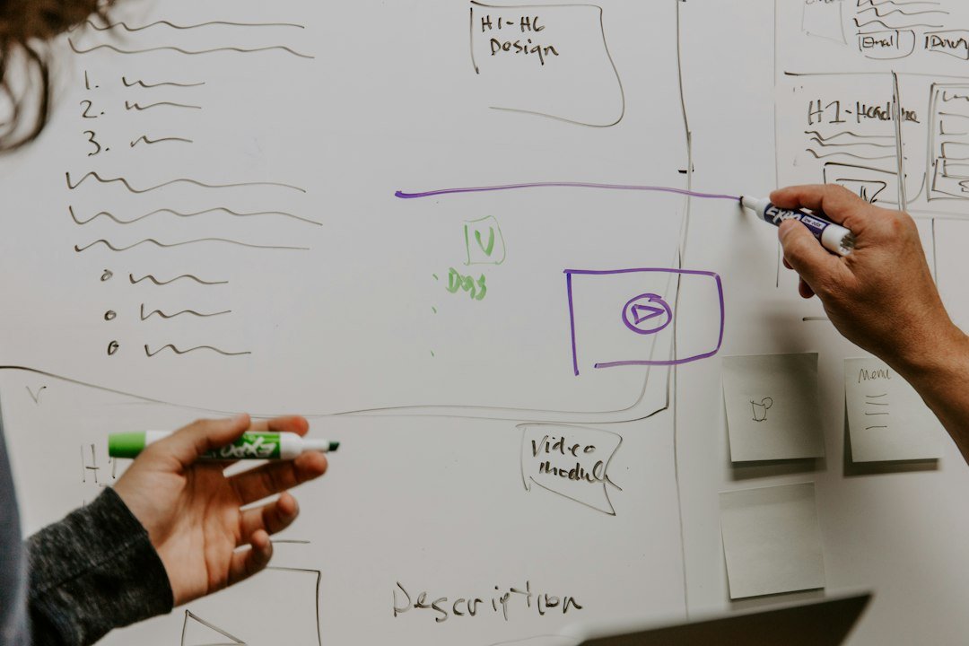 Two team members sketching ideas on a whiteboard during a brand strategy workshop