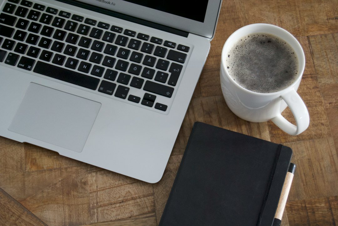 Laptop and coffee on a home desk while writing an email marketing campaign