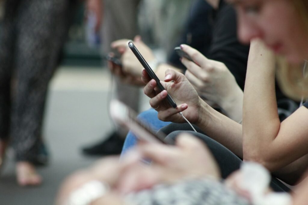 People scrolling social media feeds on smartphones, the audience for small business social media marketing