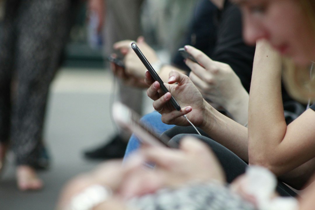 People scrolling social media feeds on smartphones, the audience for small business social media marketing